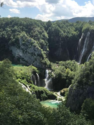 a waterfall in the middle of a forest at Apartments Paradise in Ličko Petrovo Selo