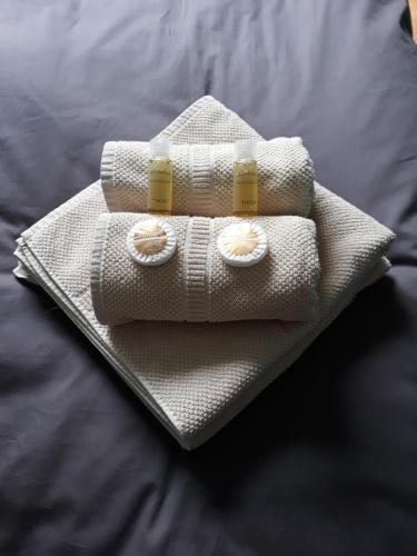 a white towel with two pill bottles on a bed at Room "Carpe Diem" in Zele