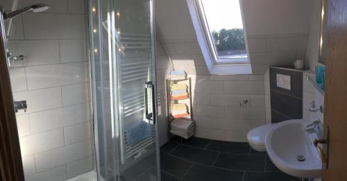 e bagno con doccia, servizi igienici e lavandino. di Ferienwohnung am Wiehen a Rödinghausen