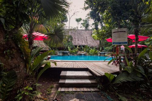 a swimming pool in a resort with a wooden deck at Hotel Hacienda Tijax Jungle Logde in Río Dulce