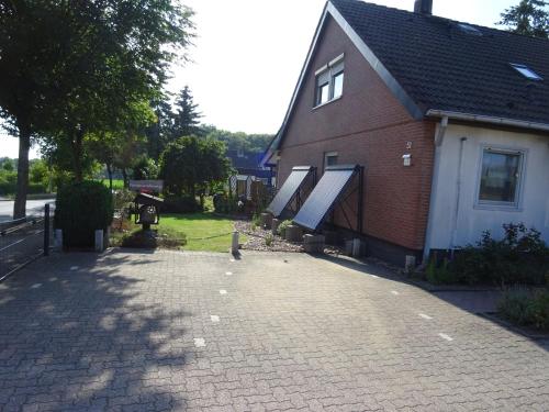 a house with a brick driveway next to a building at Ferienwohnung Ehmann in Schneverdingen