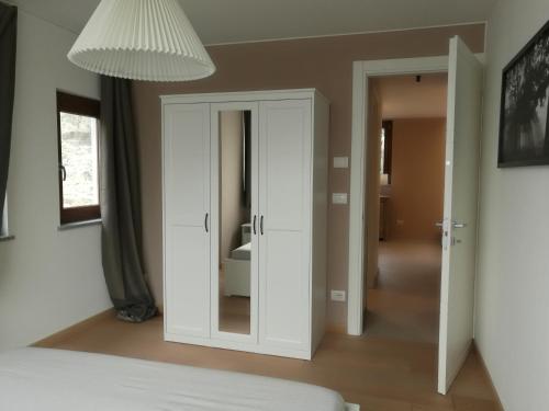 a bedroom with a white cabinet and a mirror at B&B La Maison D' Amelie Camere e Appartamenti in Fenis