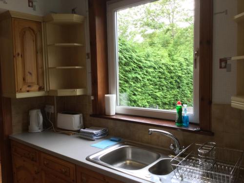 a kitchen with a sink and a window at 3 Bedroom Culduthel House Free Parking in Inverness