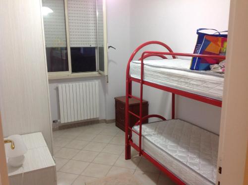 a red bunk bed in a room with a window at Appartamento al mare Puglia in Ginosa Marina