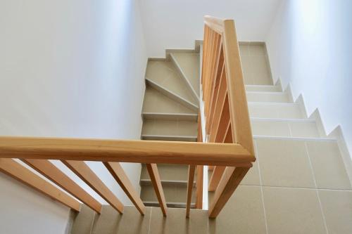 a stairwell with a wooden railing and a stair case at Apartments Milic in Kaludjerske Bare