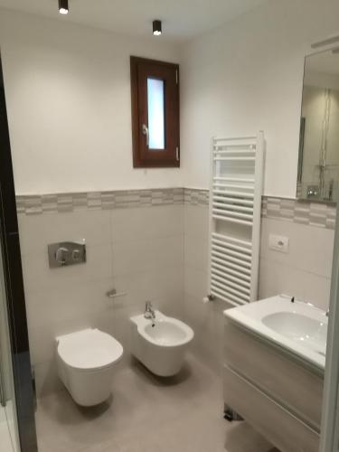 a bathroom with two sinks and a toilet and a mirror at B&B La Maison D' Amelie Camere e Appartamenti in Fenis