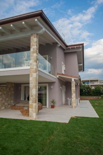 a large house with a patio and grass at Italianflat - Maison du Lac in Lazise
