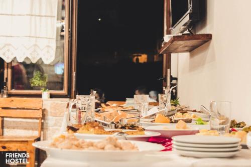 a table with plates of food on top of it at Friends' Guesthouse & Hostel in Gjirokastër
