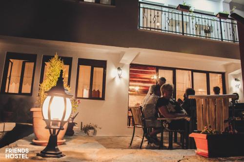 a group of people sitting at a table in a restaurant at Friends' Guesthouse & Hostel in Gjirokastër
