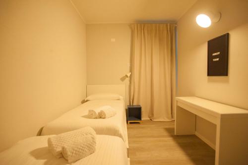 a hotel room with two beds and a desk at Italianflat - Maison du Lac in Lazise