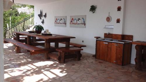 a kitchen with a table and benches in a room at Rooms Marica in Sveti Juraj