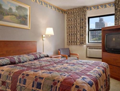 En eller flere senger på et rom på Super 8 by Wyndham Long Island City LGA Hotel