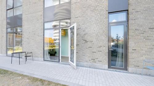 a black chair sitting outside of a brick building at The Beach apartments by Daniel&Jacob's in Copenhagen