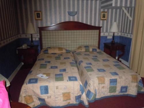 a bedroom with a bed with a quilt on it at La Croix Blanche in Montrichard