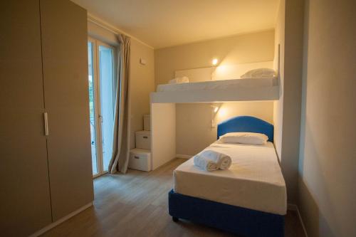 a small bedroom with a bunk bed and a window at Italianflat - Maison du Lac in Lazise