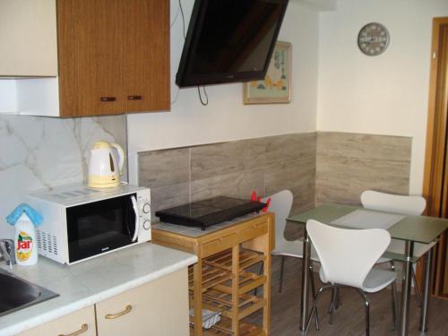 フルボカー・ナト・ヴルタヴォウにあるApartmán Polní 930のキッチン(電子レンジ、テーブル、椅子付)