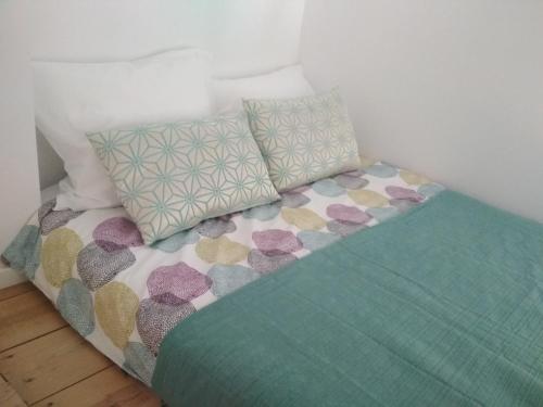 ein Bett mit bunten Kissen darüber in der Unterkunft Cassiopeia Duplex in Setúbal