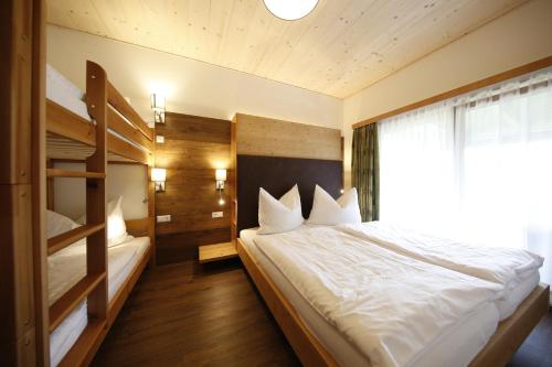 a bedroom with a bed and bunk beds and a window at Haus Mozart in Schladming