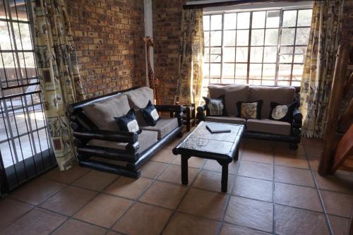 a living room with two couches and a coffee table at Giraffe plains in Marloth Park