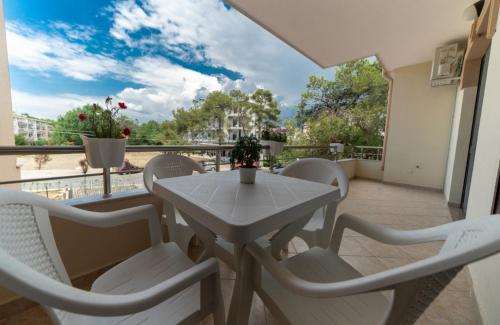 - Balcón con mesa blanca y sillas en Hotel Villa Aljor, en Golem