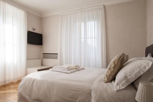a white bedroom with a large white bed with pillows at Milan Royal Suites - Centro in Milan