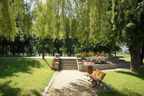 a park with a bench and some flowers and trees at Hotel Zamek Chałupki in Chałupki