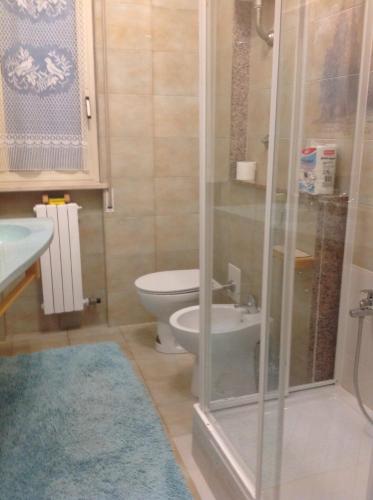 a bathroom with a toilet and a glass shower at Appartamento al mare Puglia in Ginosa Marina