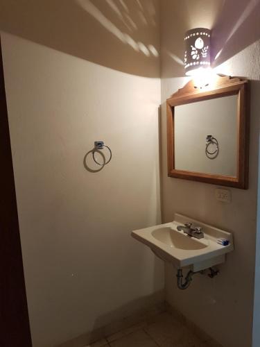 a bathroom with a sink and a mirror at Hotel Kootznoowoo in Puerto Escondido
