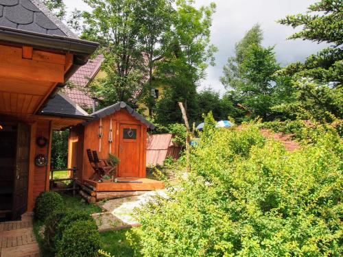 Cette maison en bois dispose d'une terrasse couverte et d'un jardin. dans l'établissement Dziko Hanka, à Kościelisko