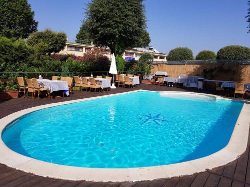 a large swimming pool with chairs and a table at Capodichino International Hotel in Naples