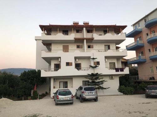 two cars parked in front of a building at Vila Balani in Ksamil