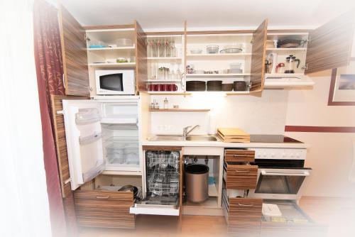 a kitchen with white appliances and wooden cabinets at Appartement Haus Moser in Sankt Michael im Lungau