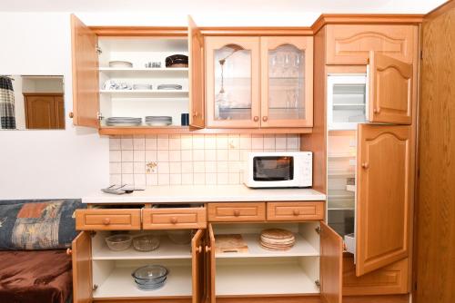 a kitchen with wooden cabinets and a microwave at Appartement Haus Moser in Sankt Michael im Lungau