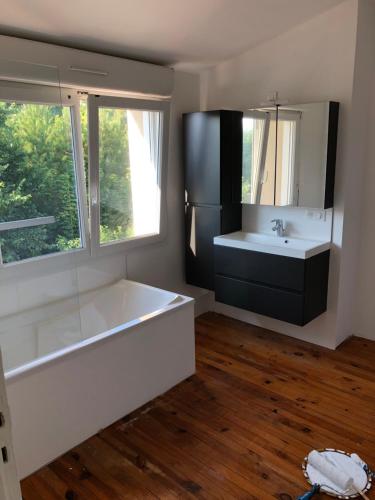 a bathroom with a tub and a sink and a mirror at Les Oyats in Camiers