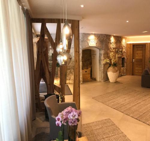 a living room with a chair and a table with flowers at Hotel Al Forte in Arabba