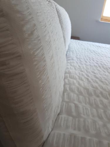 a close up of a white bed with a pillow at Prime Apartments Leeds in Leeds