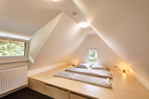 ein Schlafzimmer mit einem Bett im Dachgeschoss in der Unterkunft Chata Maruška in Harrachov