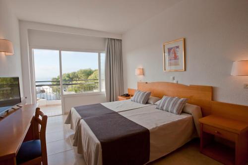 pokój hotelowy z łóżkiem i balkonem w obiekcie Cabot Cala Ferrera w mieście Cala d´Or