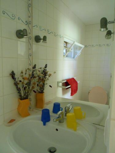 une salle de bain blanche avec un lavabo et des toilettes dans l'établissement Les Soleillas pour votre zen'ittude, à Chalencon