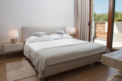 a bedroom with a large bed and a balcony at Luxury Poolside Villa in Slatine