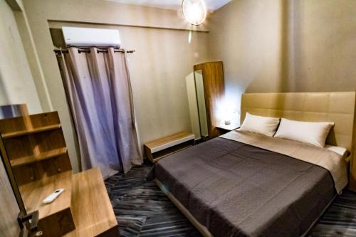1 dormitorio con 1 cama y 1 mesa en una habitación en Vickyvillas, en Neos Marmaras