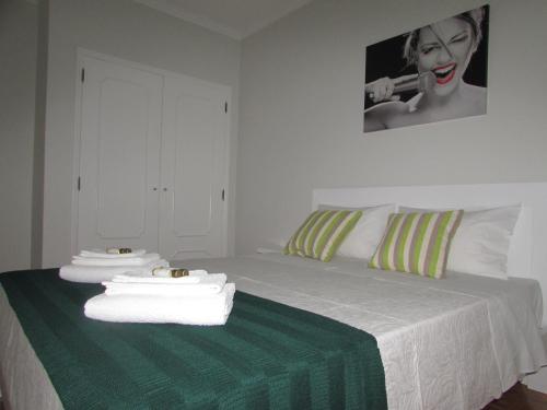 ein Schlafzimmer mit einem Bett mit Handtüchern darauf in der Unterkunft Ar Puro III in Viana do Castelo