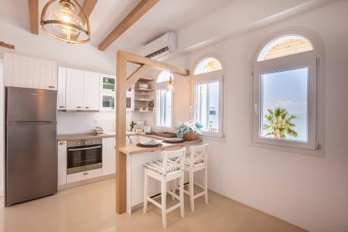a kitchen with white cabinets and a stainless steel refrigerator at Nautilus Sea View Suite 6 in Pefkohori