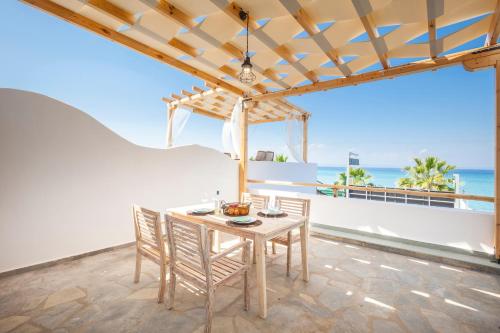 a dining room with a table and chairs and the ocean at Nautilus Sea View Suite 6 in Pefkohori