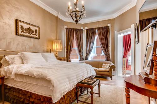a bedroom with a large bed and a chandelier at The Holiday Chalet Victorian in Denver