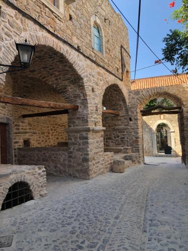 a stone building with an archway on a street at Schinos Apartments in Mesta