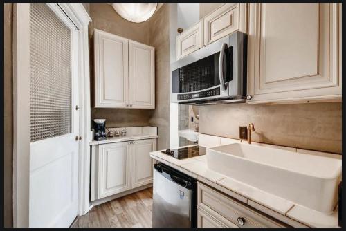 a kitchen with a sink and a microwave at The Holiday Chalet Victorian in Denver