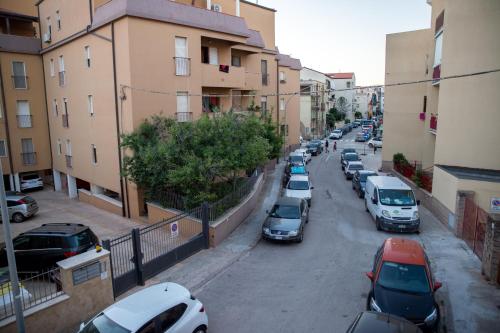 a row of cars parked on a street next to buildings at Acqua Azzurra in Alghero