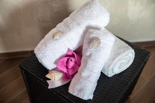 a black basket with two towels and purple flowers at Acqua Azzurra in Alghero