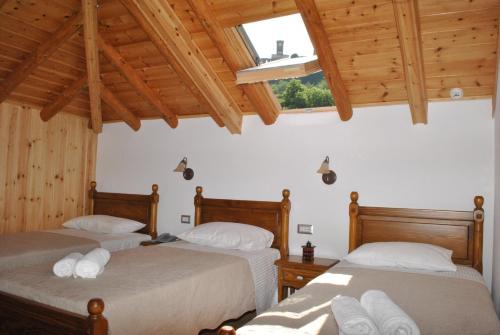 two beds in a room with wooden ceilings at Hotel Kastro in Gjirokastër